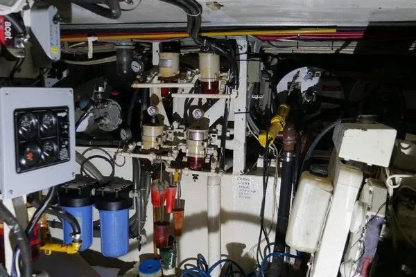 Slide: The Image of Engine room of 1989 Custom Robb Ladd Pilothouse Cutter, showcasing complex machinery and filters. - 24