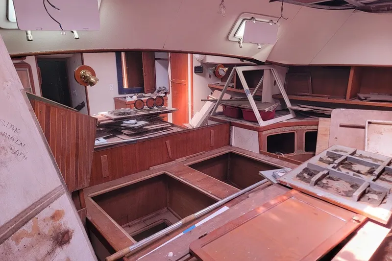 Slide: The Image of Interior of 1989 Custom Robb Ladd Pilothouse Cutter, showing unfinished woodwork and storage compartments. - 8