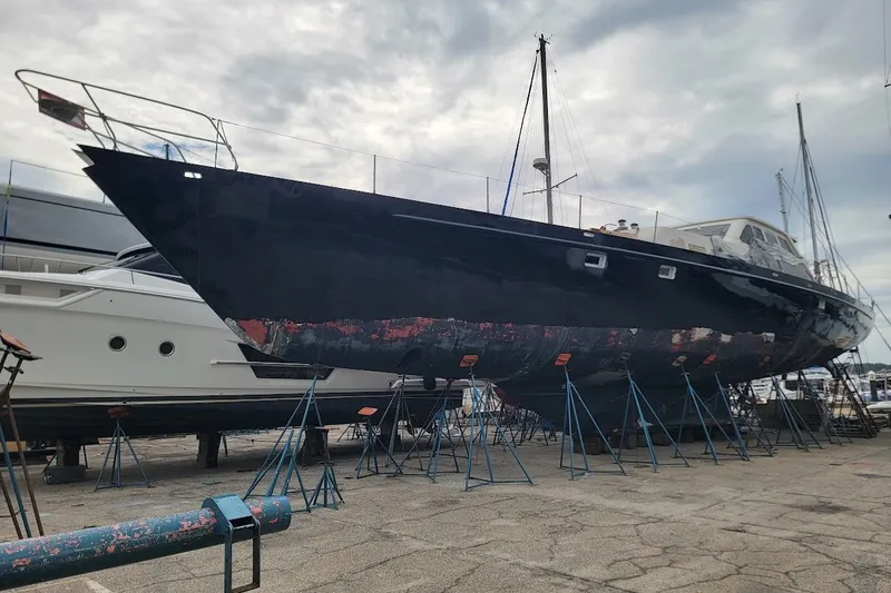 Slide: The Image of Custom 1989 Rob Ladd PH Motorsailer Cutter on stands, undergoing maintenance at a marina. - 72