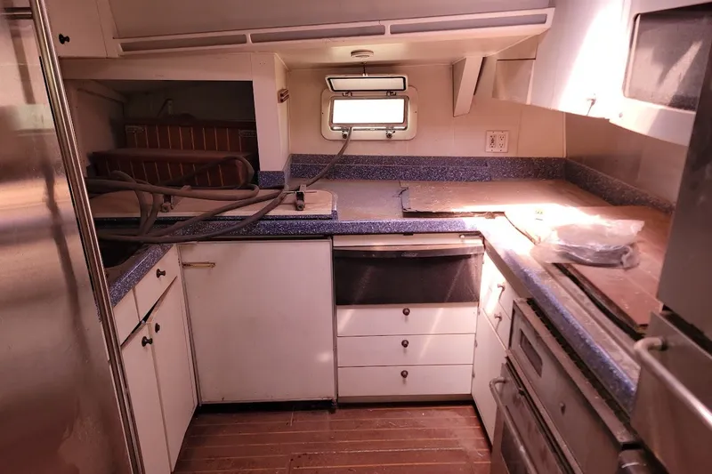 Slide: The Image of Interior of 1989 Custom Robb Ladd Pilothouse Cutter, featuring a compact kitchen area. - 17