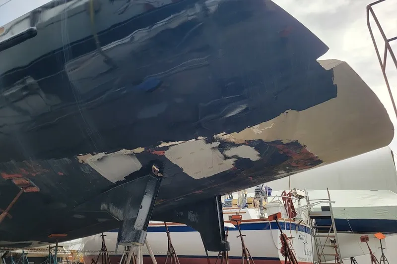 Slide: The Image of 1989 Custom Rob Ladd PH Motorsailer Cutter under repair, showing hull damage and restoration work. - 78