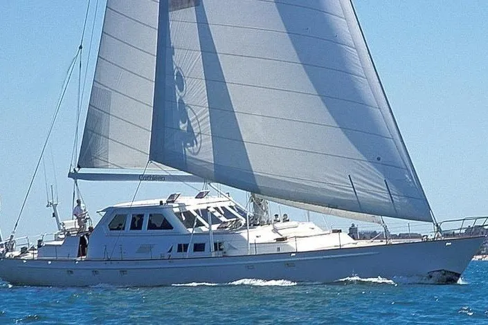 Slide: The Image of A white sailboat cutter with large sails cruising on calm waters. - 29