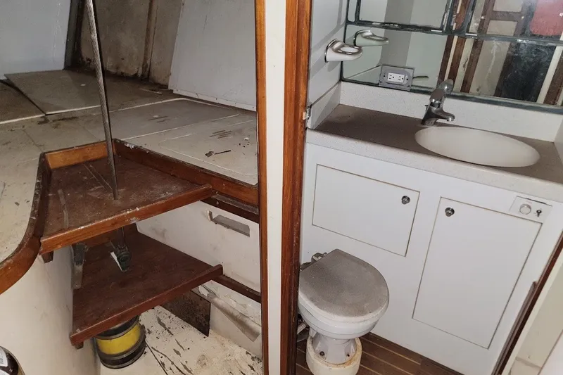 Slide: The Image of Interior of 1989 Custom Rob Ladd PH Motorsailer Cutter, featuring a compact bathroom and wooden steps. - 59