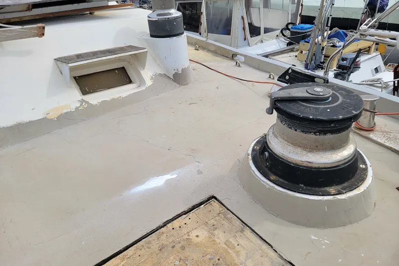 Slide: The Image of Deck of 1989 Custom Rob Ladd PH Motorsailer Cutter, featuring winch and hatch. - 54