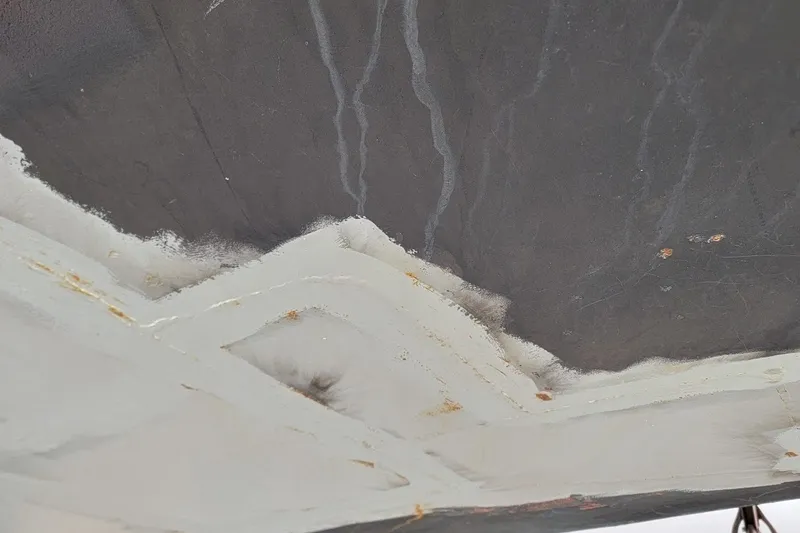 Slide: The Image of Close-up of hull surface on 1989 Custom Rob Ladd PH Motorsailer Cutter, showing wear and repair. - 63