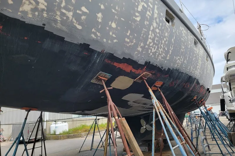 Slide: The Image of Custom 1989 Rob Ladd PH Motorsailer Cutter under restoration, supported by stands in a shipyard. - 75