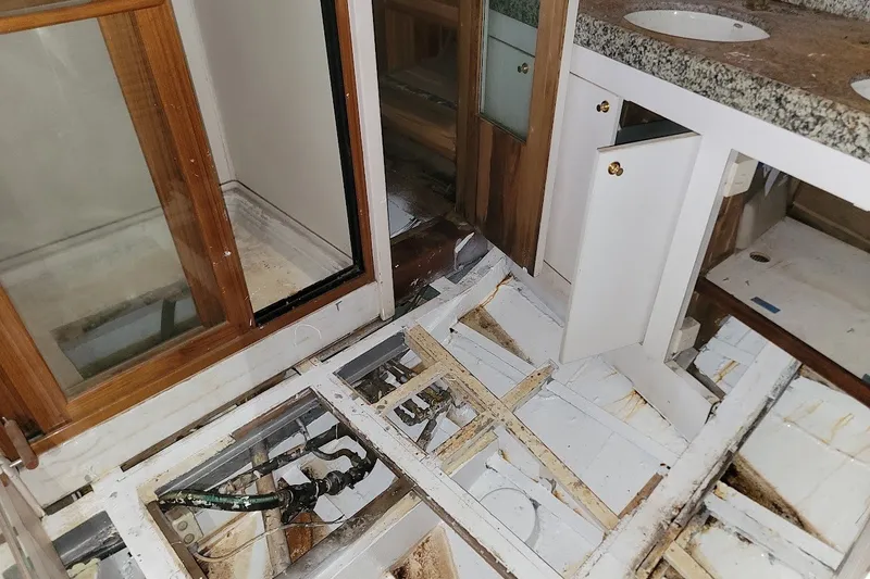 Slide: The Image of Interior view of a 1989 Rob Ladd PH Motorsailer Cutter project, showing exposed flooring and cabinetry. - 41