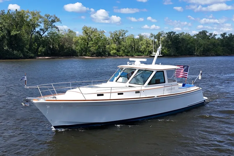 The Image of Alden 40 Express 1999 yacht cruising on a river under a clear blue sky. - 0