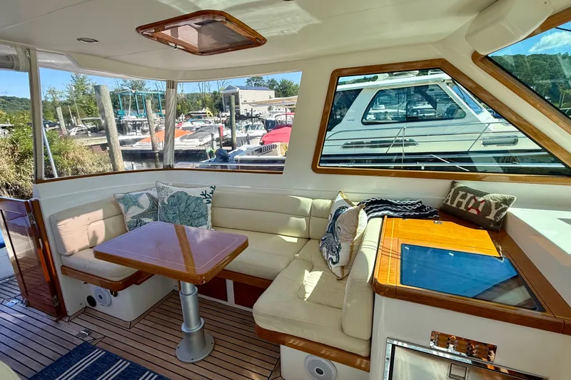 Slide: The Image of Interior of 1999 Alden 40 Express yacht with cozy seating and marina view. - 32