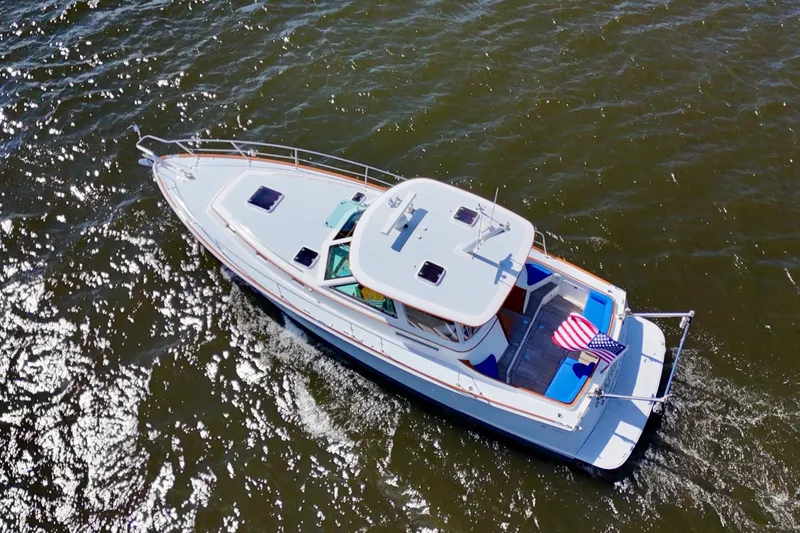 Slide: The Image of Aerial view of 1999 Alden 40 Express yacht cruising on water with American flag. - 7