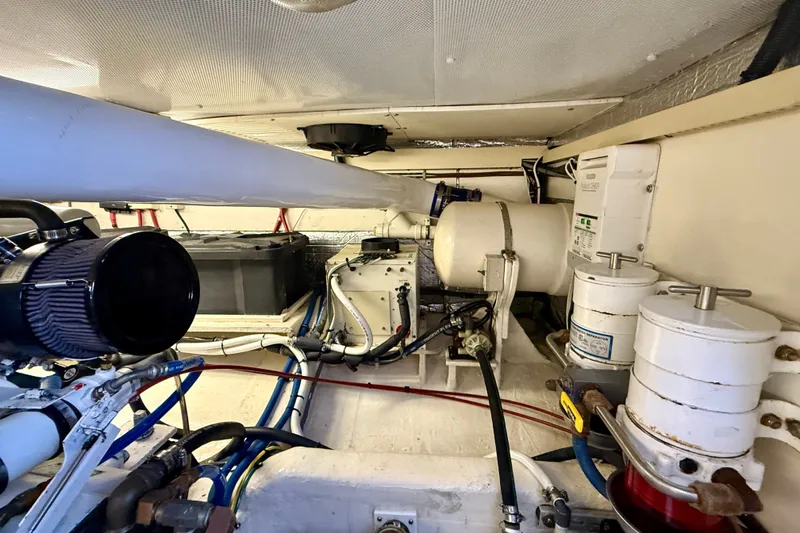Slide: The Image of Engine room of a 1999 Alden 40 Express boat, showcasing mechanical components and wiring. - 56