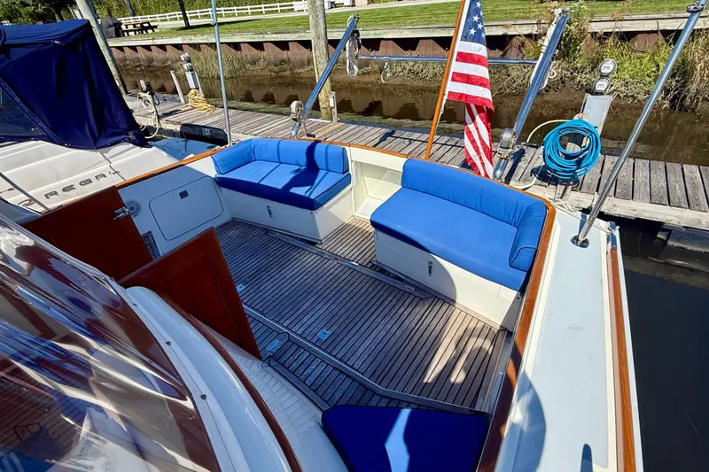 Slide: The Image of 1999 Alden 40 Express yacht with blue seating and American flag at dock. - 13