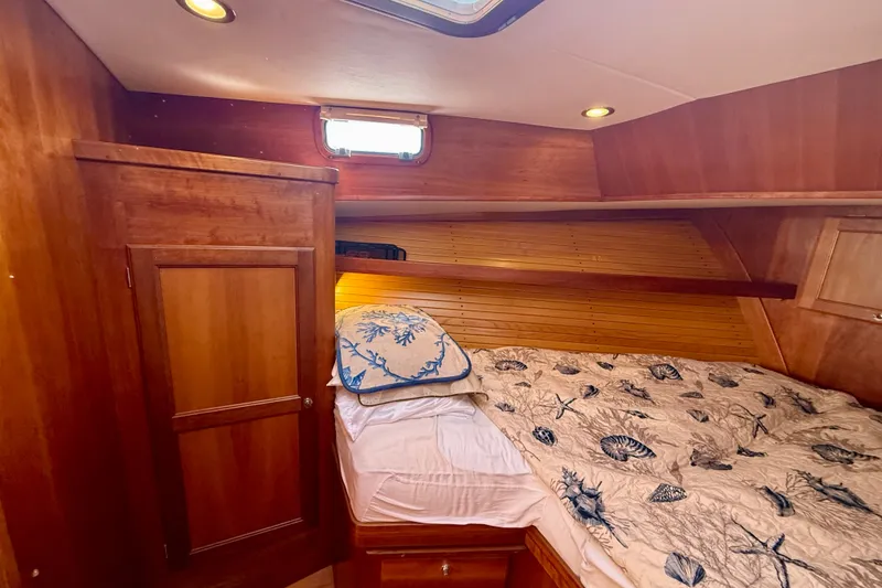 Slide: The Image of Cozy cabin interior of 1999 Alden 40 Express yacht with wooden finish and nautical bedding. - 47