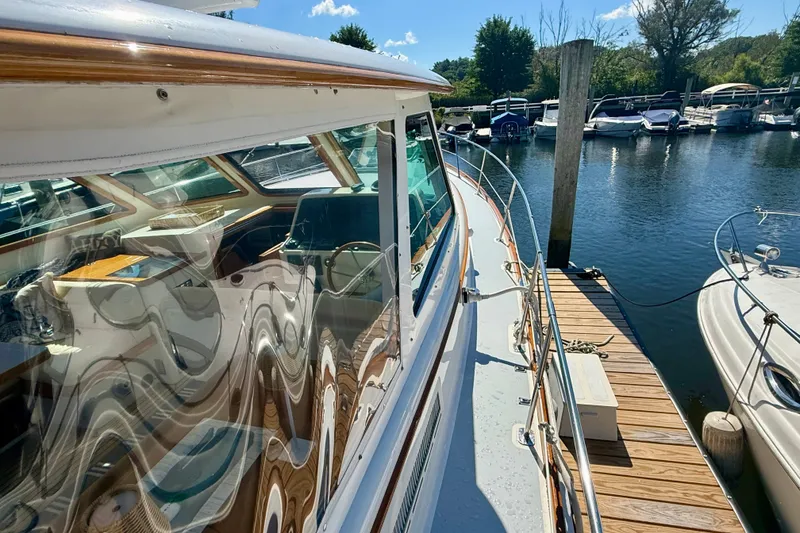 Slide: The Image of 1999 Alden 40 Express yacht docked at marina, showcasing sleek design and wooden accents. - 15