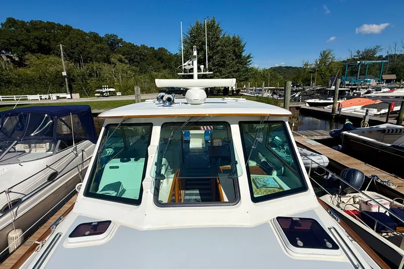 Slide: The Image of 1999 Alden 40 Express boat docked at a marina under clear blue skies. - 24