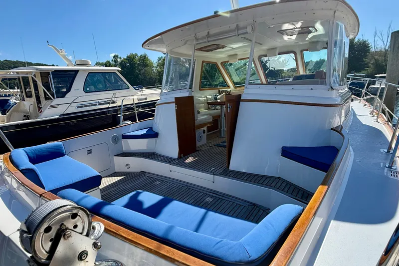 Slide: The Image of 1999 Alden 40 Express yacht with blue cushioned seating and elegant wooden accents. - 11
