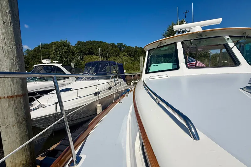 Slide: The Image of 1999 Alden 40 Express yacht docked alongside other boats on a sunny day. - 28