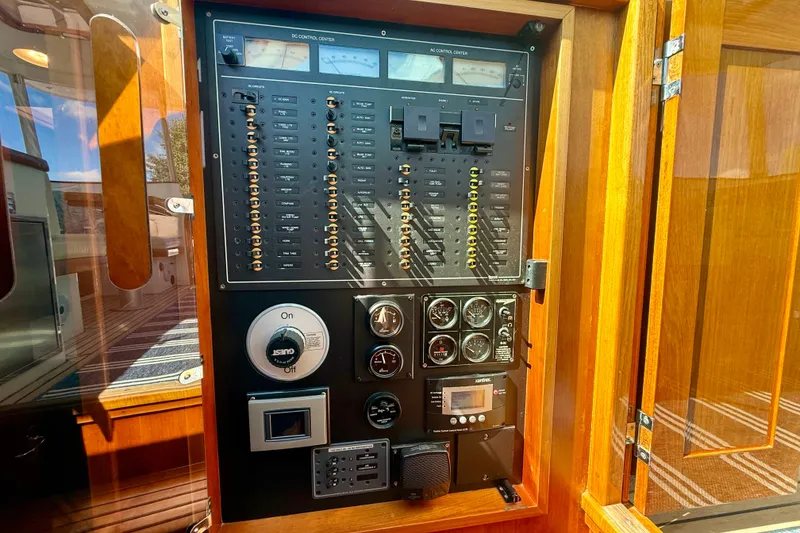 Slide: The Image of Electrical control panel on a 1999 Alden 40 Express yacht, featuring gauges and switches. - 52