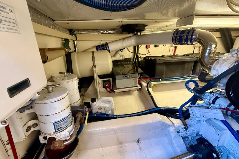 Slide: The Image of Engine room of 1999 Alden 40 Express yacht, showcasing mechanical components and piping. - 55