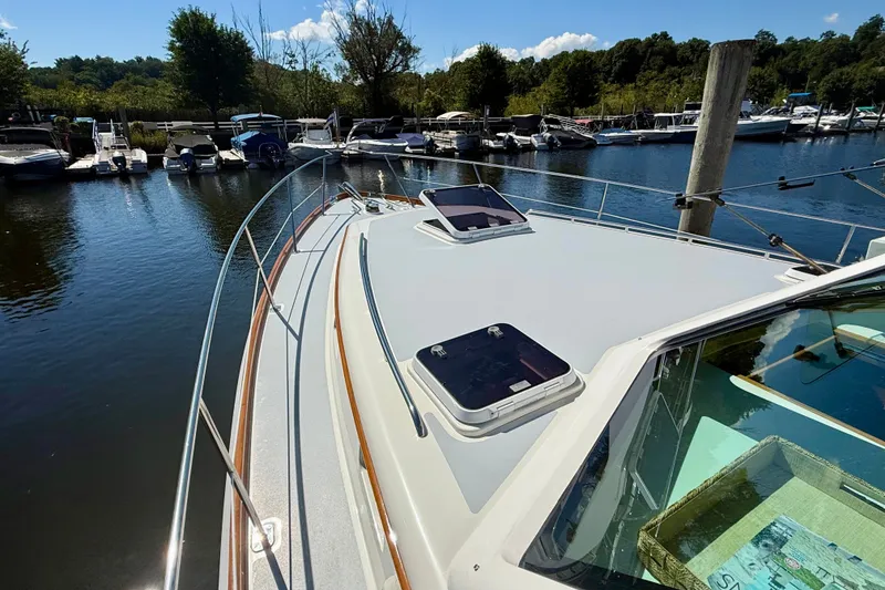 Slide: The Image of 1999 Alden 40 Express yacht docked at a marina, surrounded by trees and boats. - 17