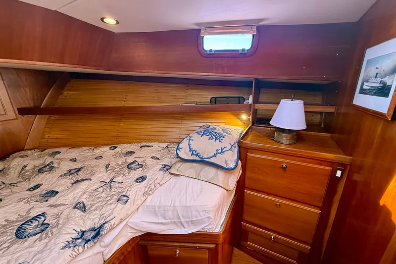 Slide: The Image of Cozy cabin interior of 1999 Alden 40 Express with nautical-themed bedding and wooden furnishings. - 48
