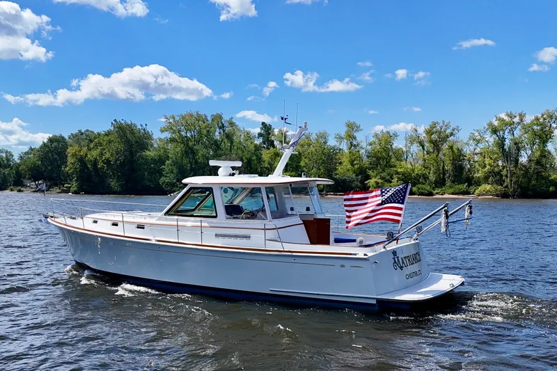 Slide: The Image of Alden 40 Express 1999 boat cruising on a sunny day with American flag. - 4