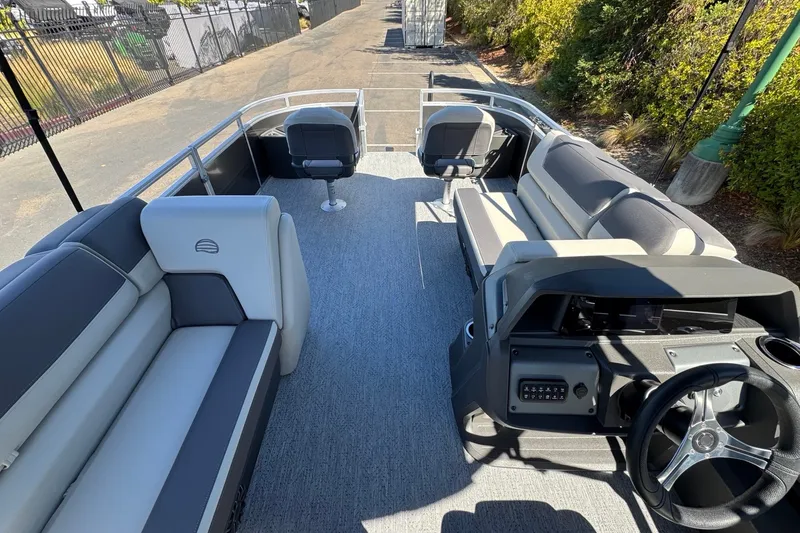 Slide: The Image of 2026 Sun Tracker Fishin' Barge 22 DLX interior with seating and steering console. - 13