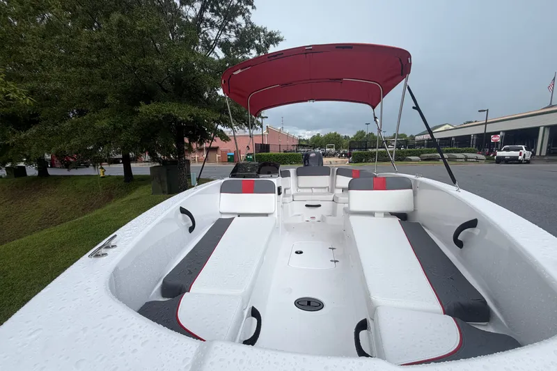 Slide: The Image of 2027 Tahoe T18 boat with red canopy, sleek seating, and modern design in a parking area. - 7