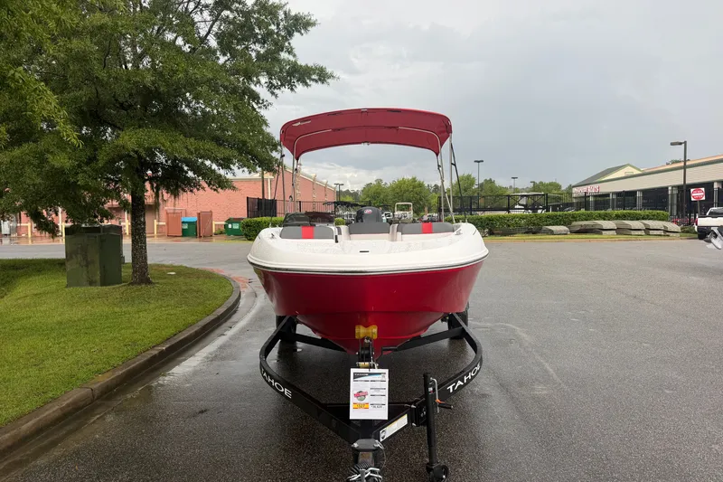 Slide: The Image of 2027 Tahoe T18 boat with red canopy on a trailer in a parking lot. - 1