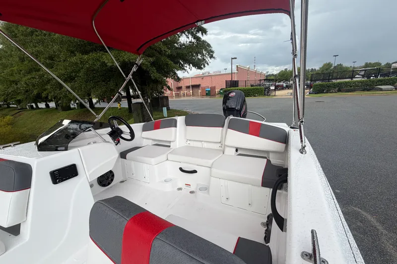 Slide: The Image of 2027 Tahoe T18 boat interior with red and gray seating, steering wheel, and canopy. - 5