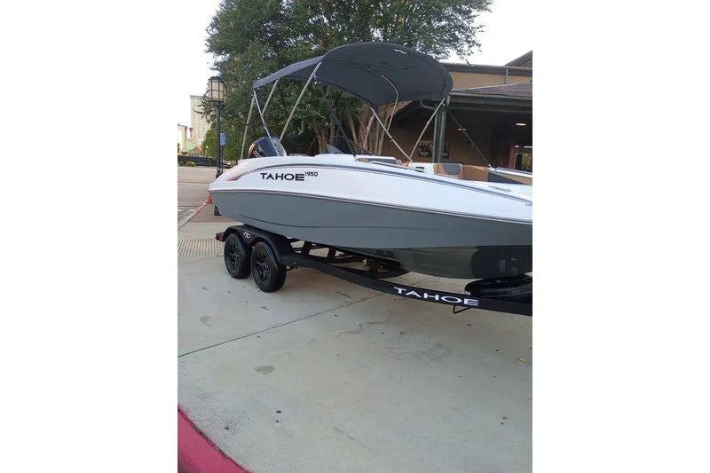 Slide: The Image of 2027 Tahoe 1950 boat on trailer, parked outdoors with canopy and sleek design. - 8