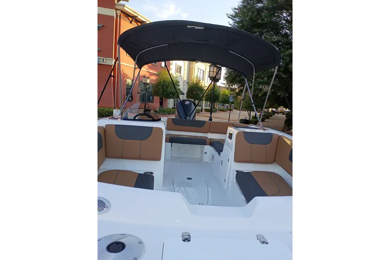 Slide: The Image of 2027 Tahoe 1950 boat interior with seating and canopy, parked near buildings. - 11