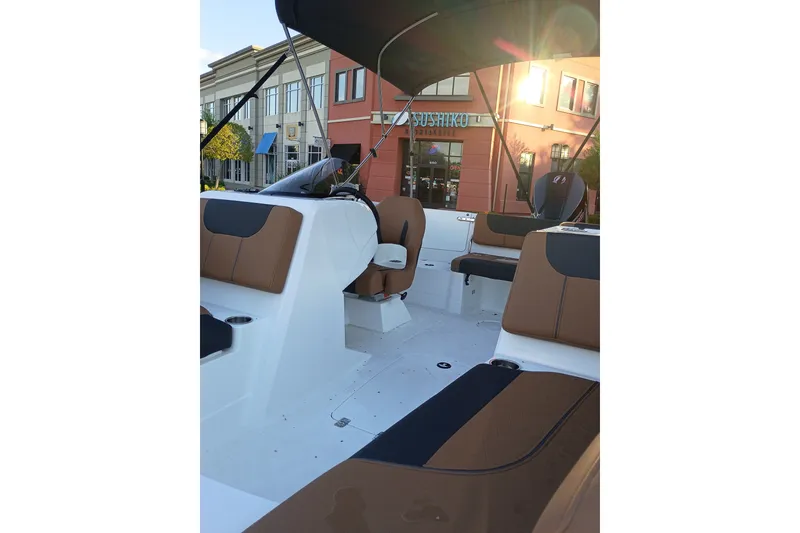 Slide: The Image of Interior of 2027 Tahoe 1950 boat with brown and black seating, outdoor setting. - 10