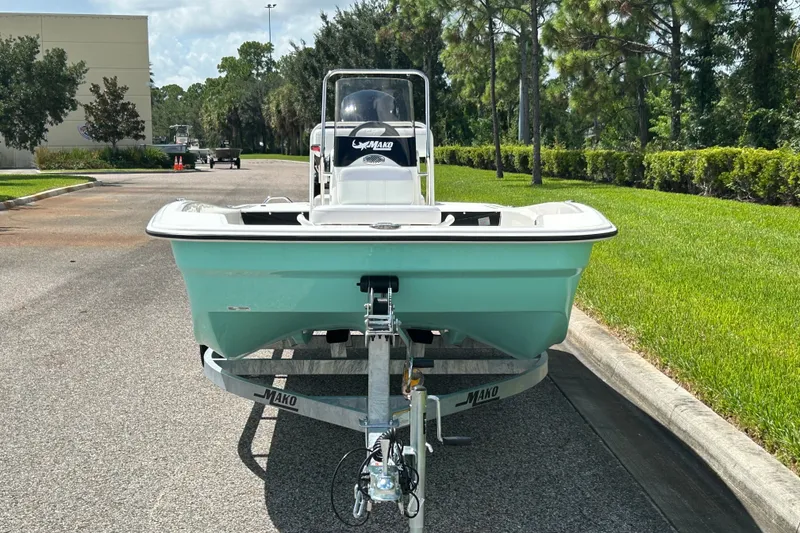 Slide: The Image of 2027 Mako Pro Skiff 17 CC boat on trailer, parked on a sunny street. - 2