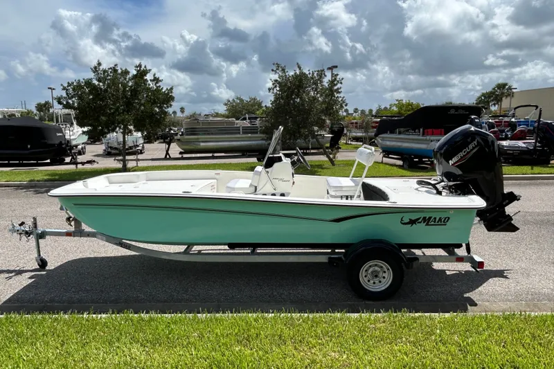Slide: The Image of 2027 Mako Pro Skiff 17 CC boat on trailer, parked outdoors under cloudy sky. - 4
