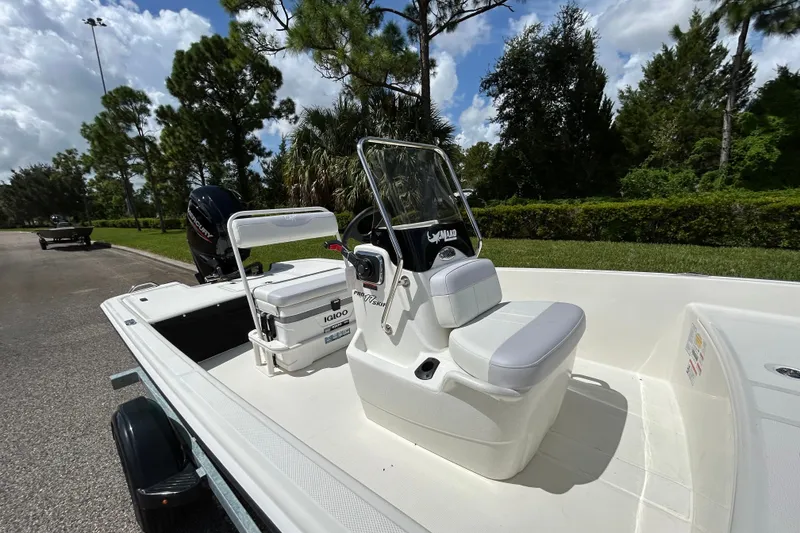 Slide: The Image of 2027 Mako Pro Skiff 17 CC boat with console and seating, parked outdoors. - 9