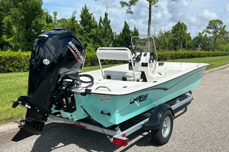 Slide: The Image of 2027 Mako Pro Skiff 17 CC boat on trailer, featuring a Mercury outboard motor. - 6
