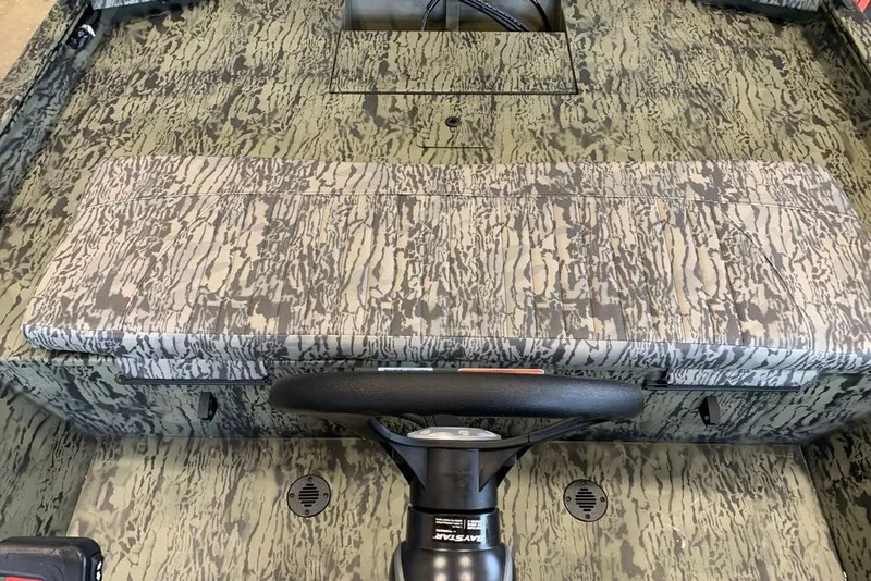 Slide: The Image of 2027 Tracker Grizzly 1860 CC boat interior with camouflage seating and steering wheel. - 13