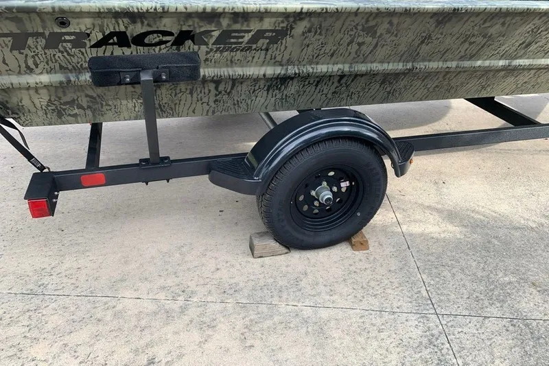 Slide: The Image of 2027 Tracker Grizzly 1860 CC boat on trailer, parked on concrete surface. - 14