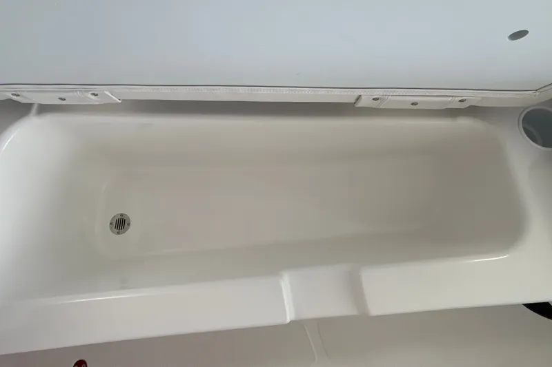 Slide: The Image of White interior compartment of 2027 Tahoe T18 boat, featuring a drain. - 23