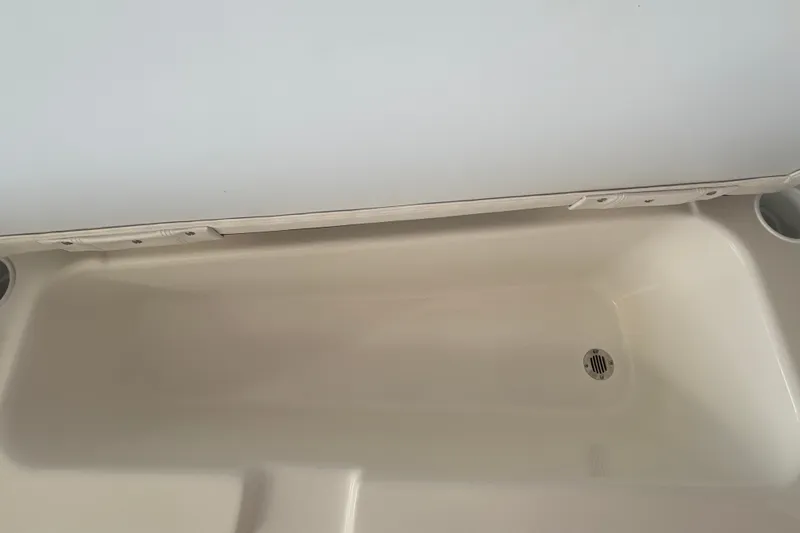 Slide: The Image of 2027 Tahoe T18 boat storage compartment with drain plug. - 24