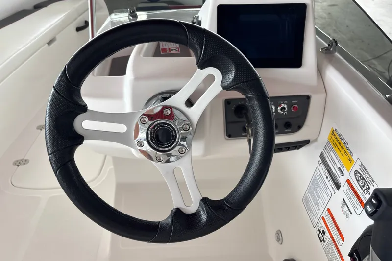 Slide: The Image of Steering wheel and dashboard of 2027 Tahoe T18 boat, featuring modern controls and display. - 15