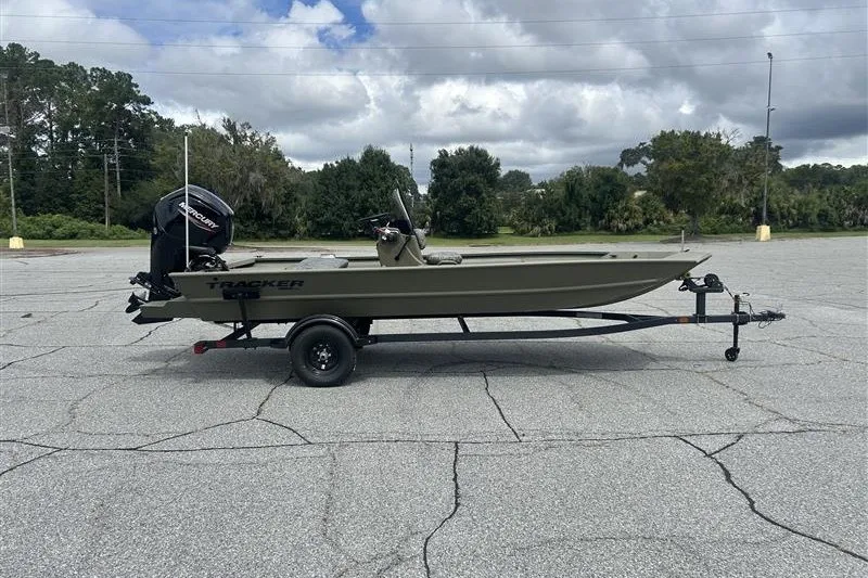 The Image of 2027 Tracker Grizzly 1860 CC boat on trailer in parking lot, cloudy sky background. - 0