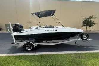 The Image of 2027 Tahoe T18 boat on trailer, parked outdoors with a canopy. - 0