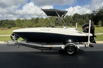 Slide: The Image of 2027 Tahoe T18 boat on trailer, parked outdoors under cloudy sky. - 1