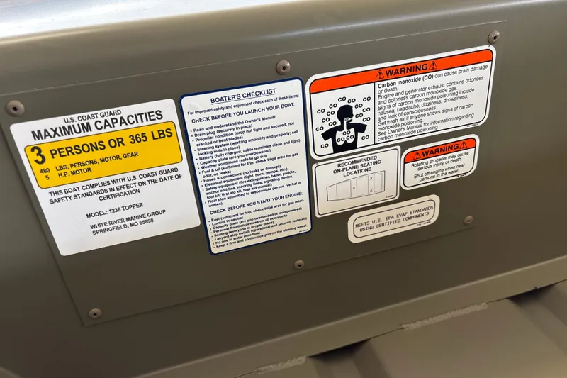 Slide: The Image of 2027 Tracker Grizzly 12 Jon boat capacity and safety warning labels. - 14