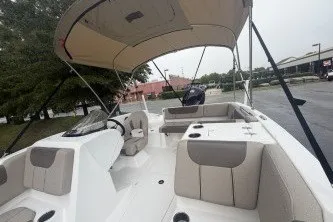 Slide: The Image of 2027 Tahoe 1950 boat with spacious seating and canopy, parked outdoors. - 6