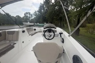 Slide: The Image of 2027 Tahoe 1950 boat interior with steering wheel, seating, and lush greenery in the background. - 3