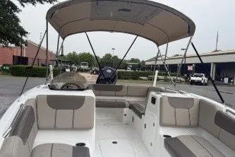 Slide: The Image of 2027 Tahoe 1950 boat with spacious seating and canopy in a parking area. - 5