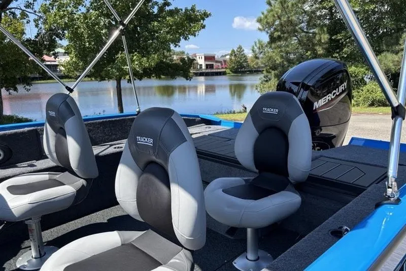 Slide: The Image of 2027 Tracker Pro Guide V-175 Combo boat interior with Mercury engine by a lake. - 15